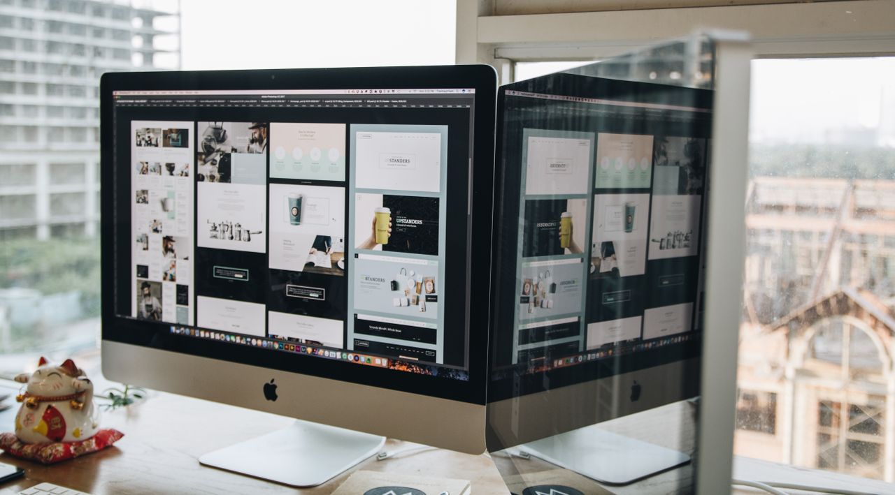 project-02-b Dual monitors on a desk, showcasing web design in a modern office setting.